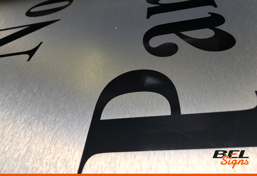Black CAD cut vinyl on brushed stainless steel | Signage