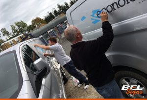 Our install team working on van graphics on-site | BEL